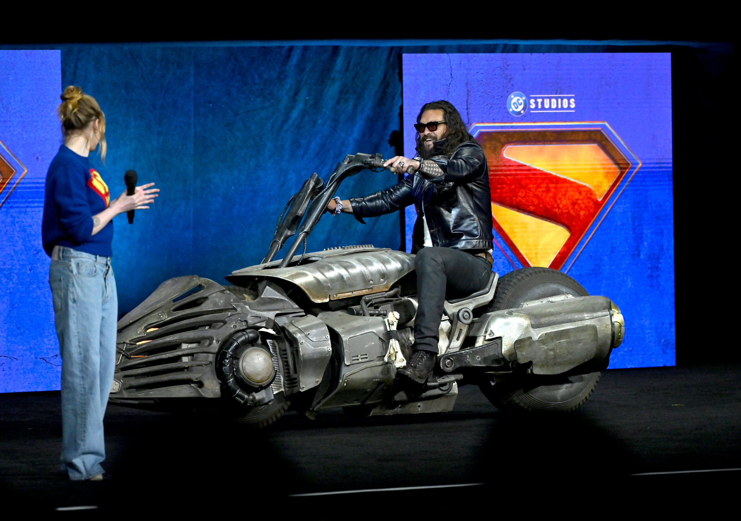 Milly Alcock and Jason Momoa discussing their roles in "Supergirl." - The Latino Slant