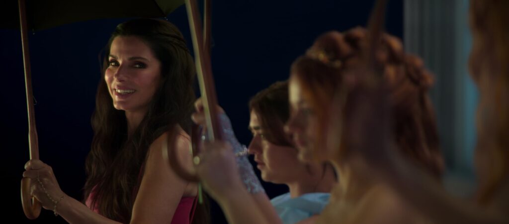 Sally shares a smile amid an evening gathering in "Practical Magic 2." - The Latino Slant