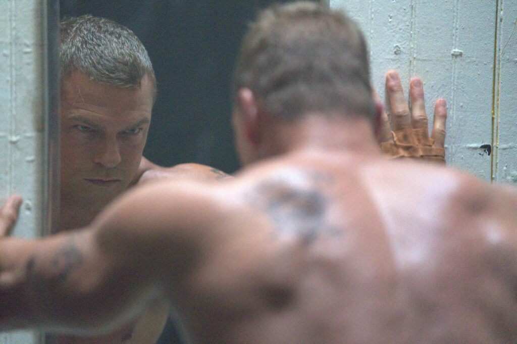 Ritchson catches his own reflection in a prison bathroom mirror in "Motor City." - The Latino Slant