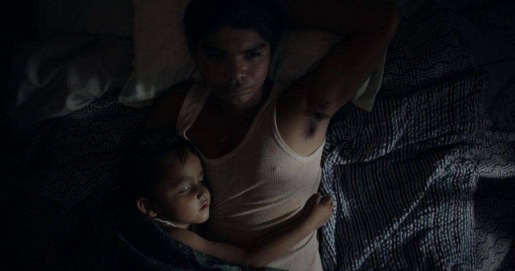 Young Sujo sleeps beside his father in "Sujo." - The Latino Slant