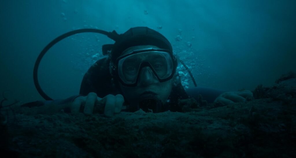 Austin Abrams dives off California’s Central Coast in "Whalefall." - The Latino Slant