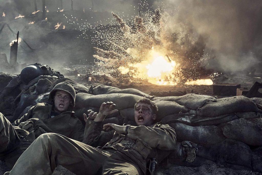 Two Marines take cover behind sandbags as an explosion erupts in “The Mosquito Bowl.” - The Latino Slant